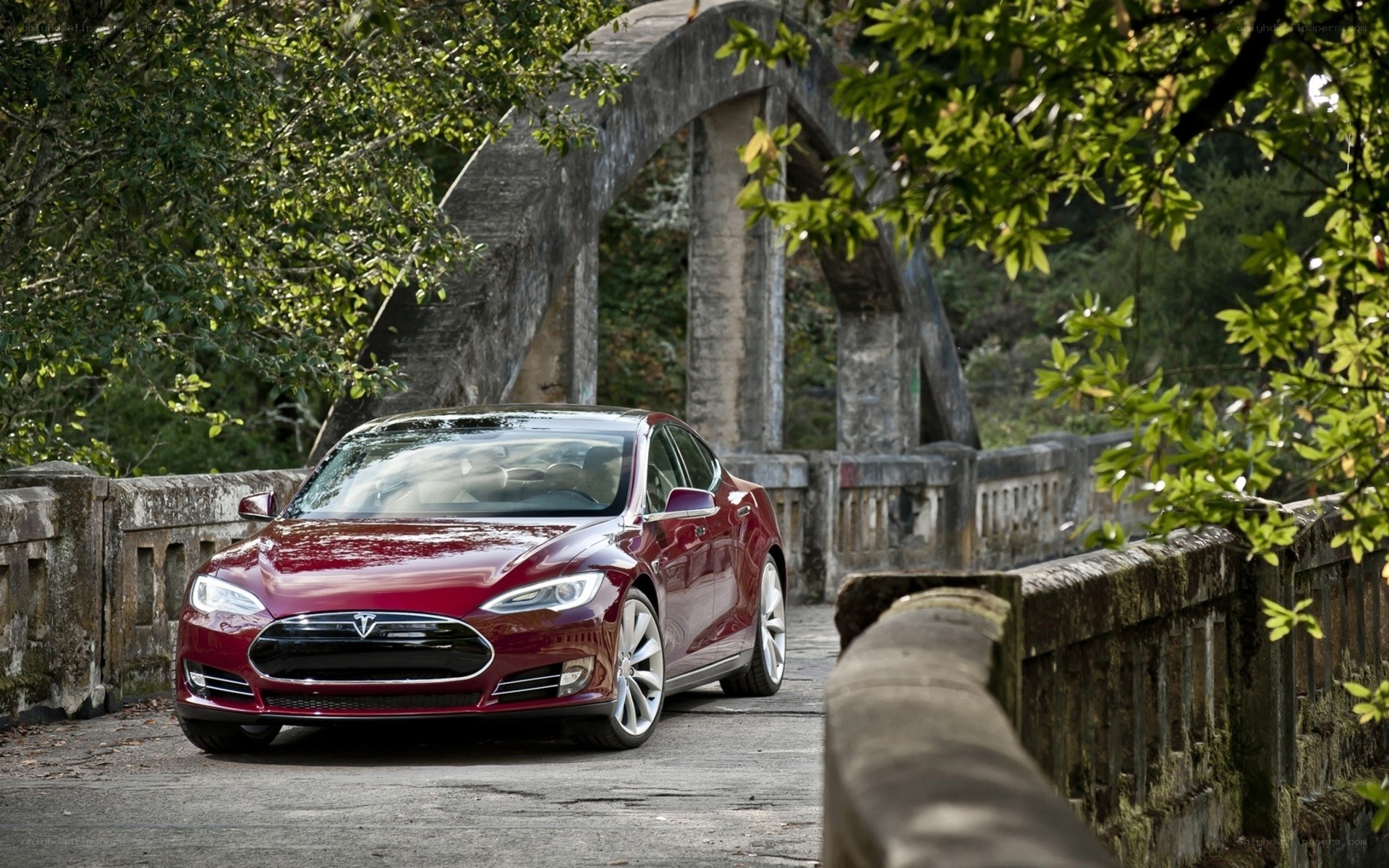 Red Tesla on a stone bridge