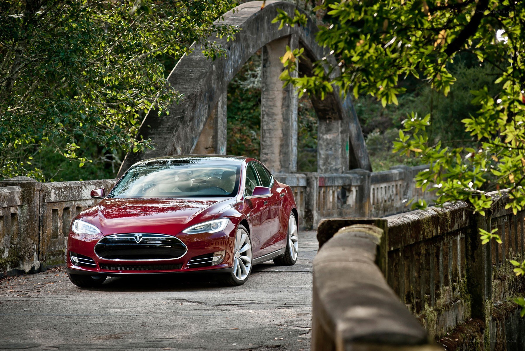 Red Tesla on a stone bridge