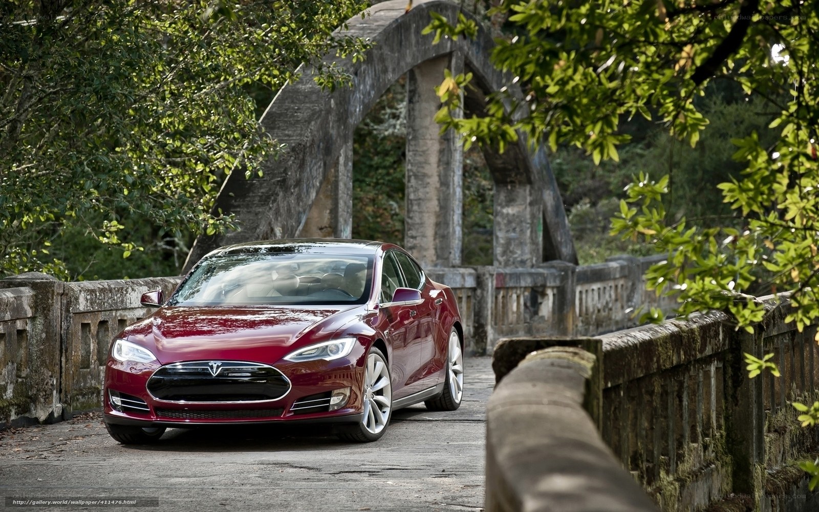 Red Tesla on a stone bridge