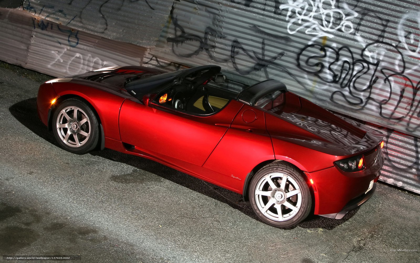 Red Tesla Roadster at night