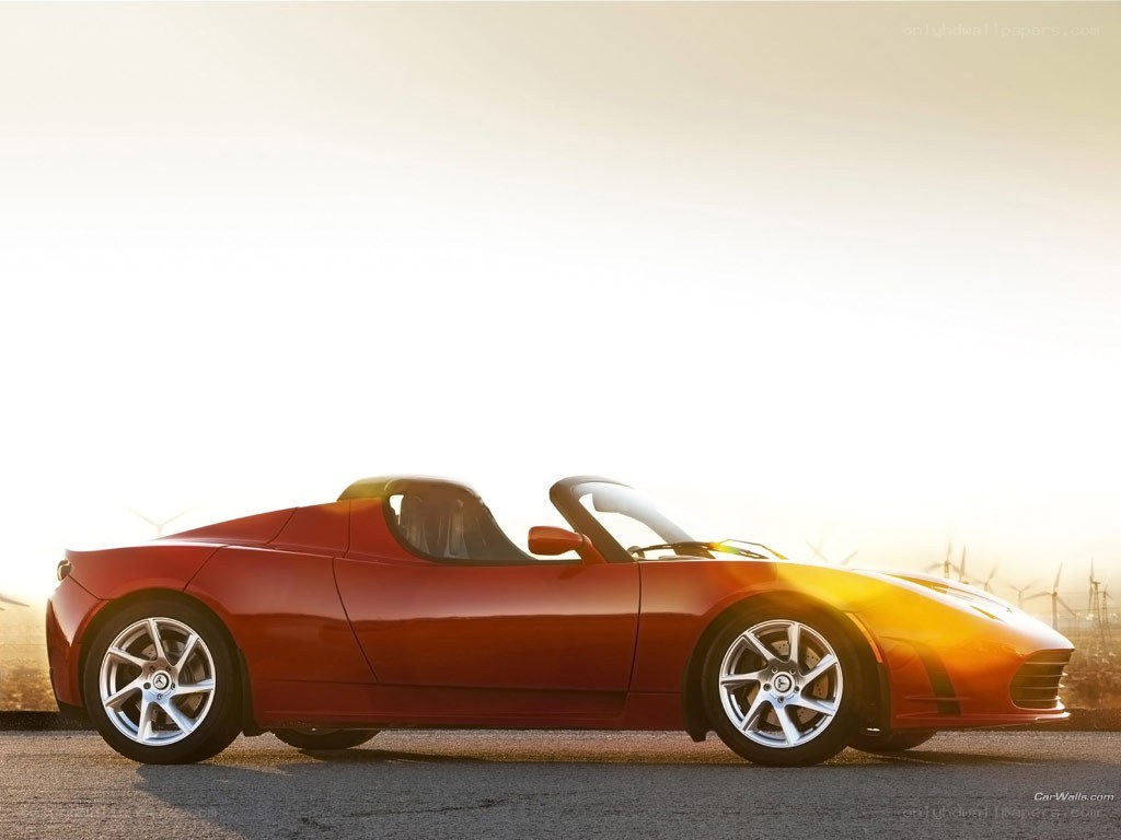 Red Tesla Roadster at sunset