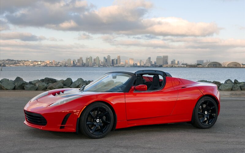 Red Tesla Roadster by the water