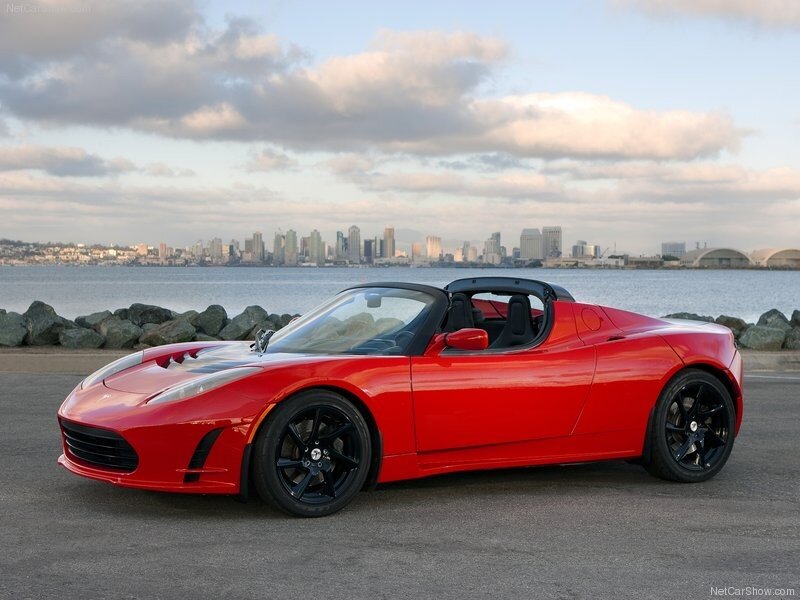 Red Tesla Roadster by waterfront