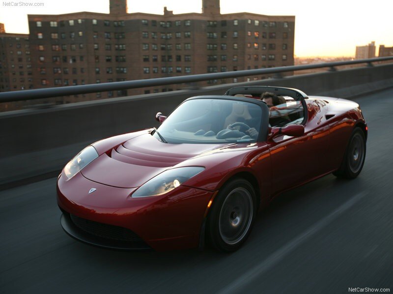 Red Tesla Roadster driving on a bridge