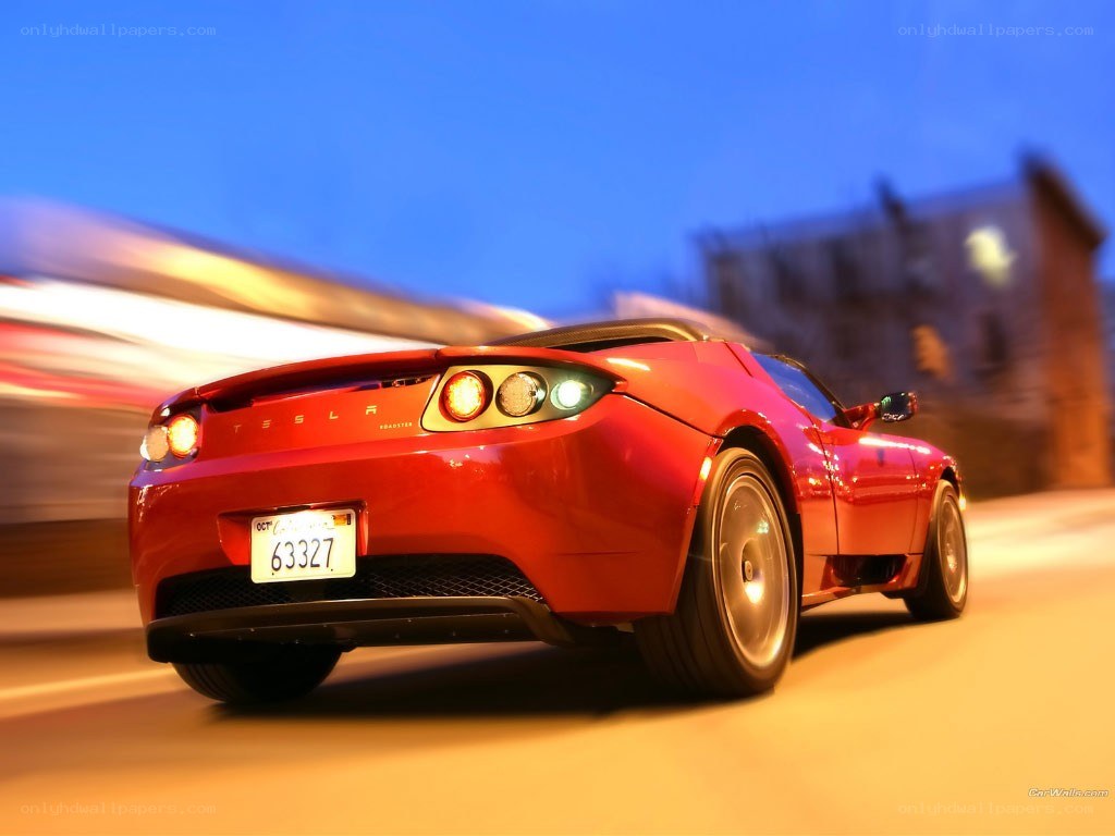 Red Tesla Roadster in motion