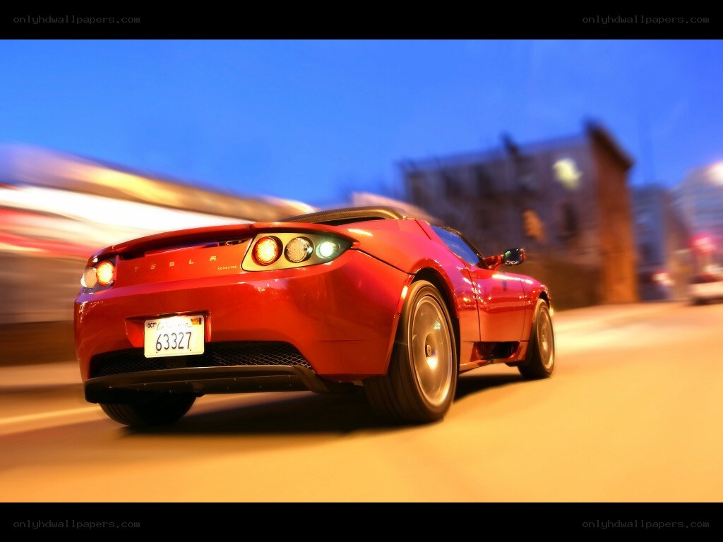 Red Tesla Roadster in motion