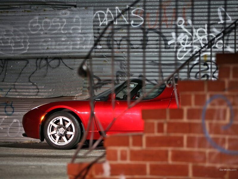 Red Tesla Roadster in urban alley