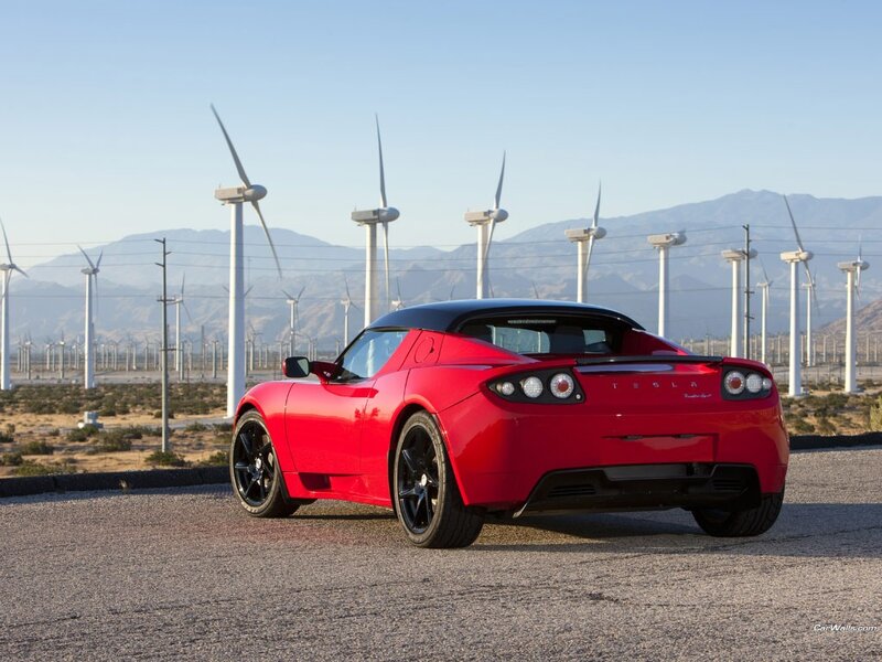 Red Tesla Roadster in wind farm