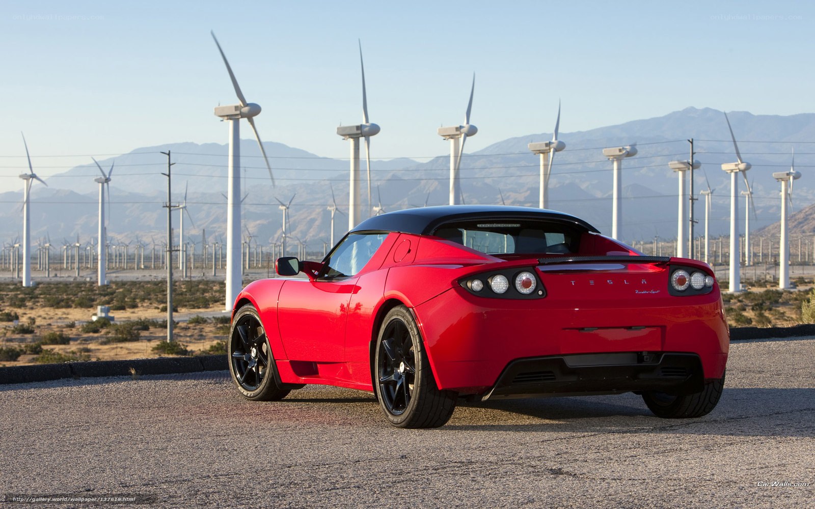 Red Tesla Roadster in wind farm