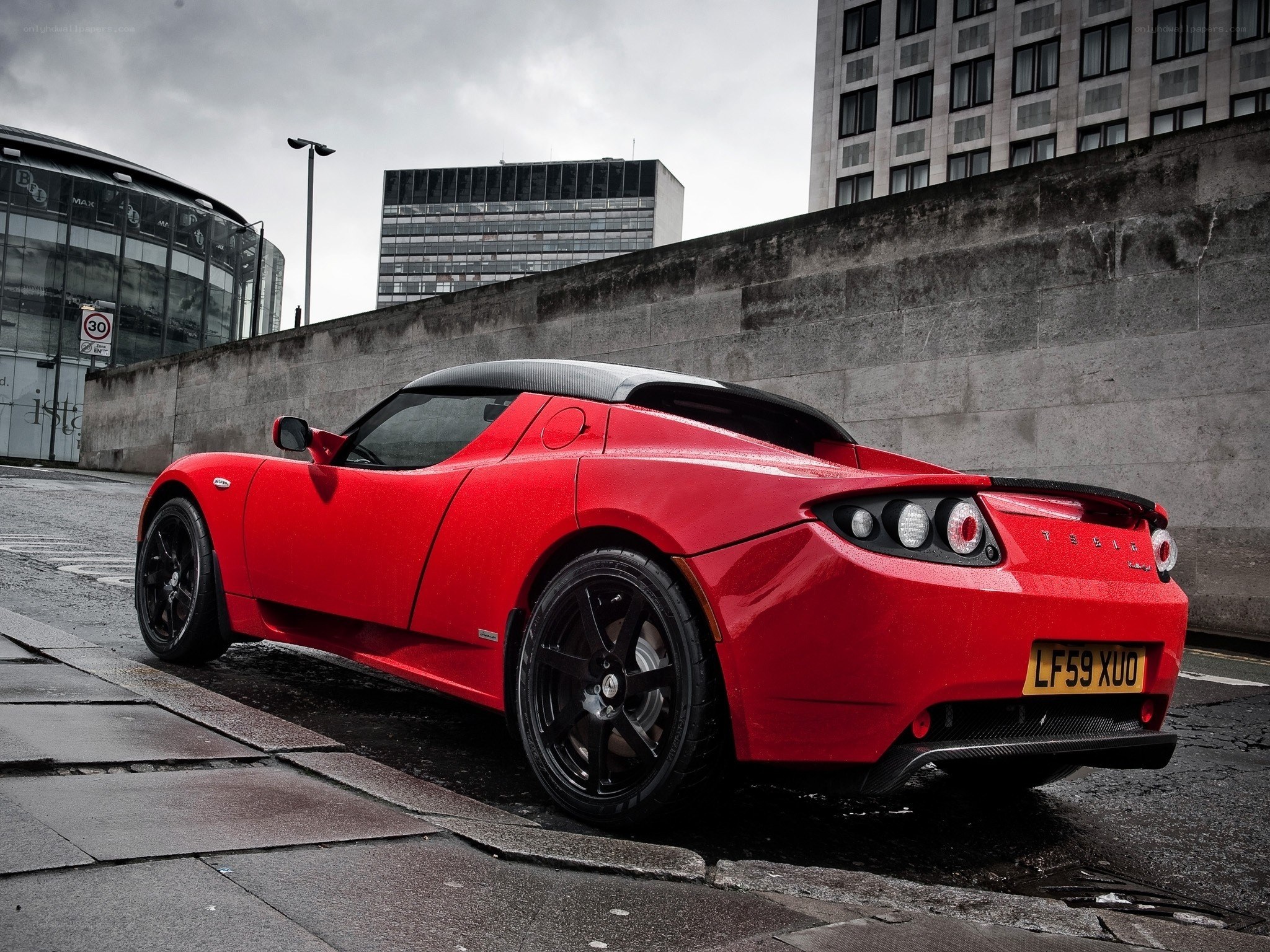 Red Tesla Roadster on city street