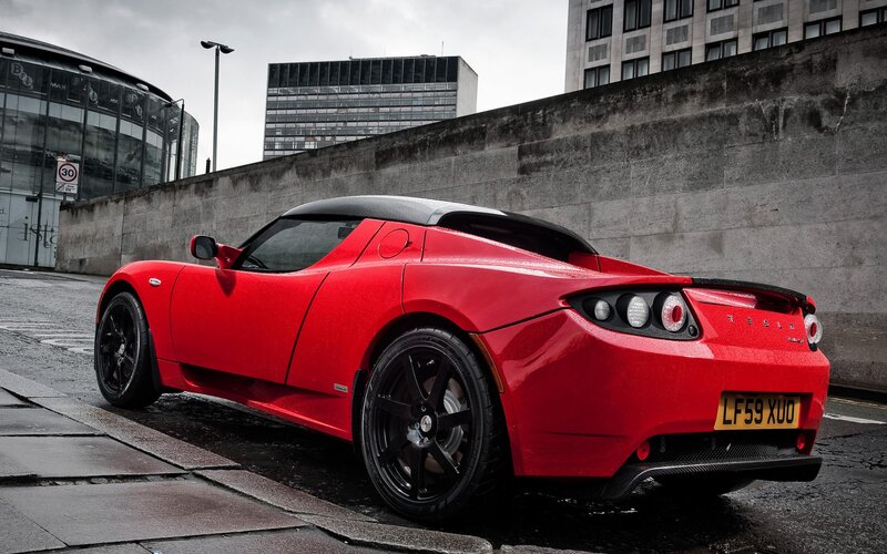 Red Tesla Roadster on city street