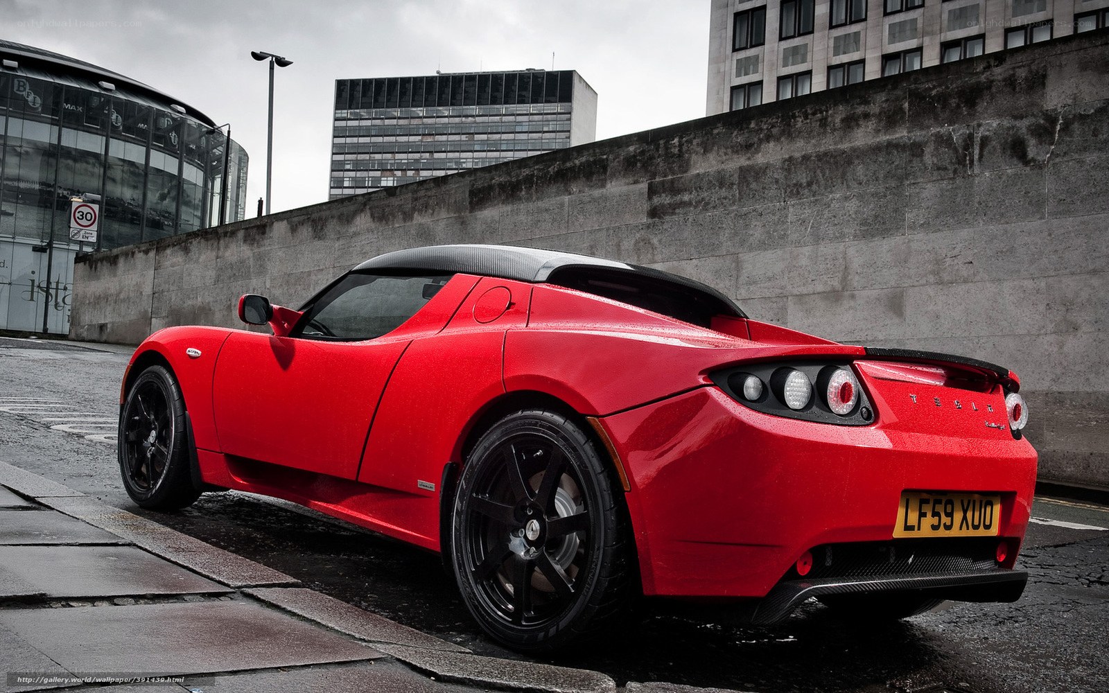 Red Tesla Roadster on city street