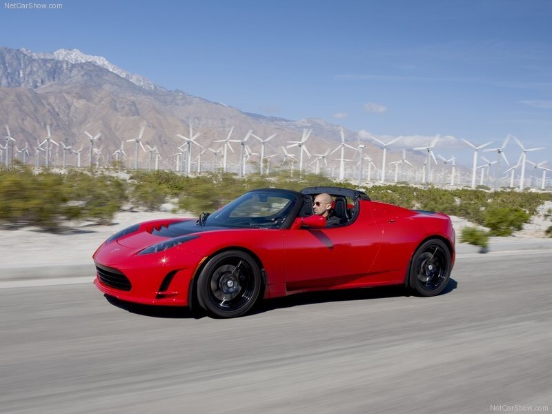 Red Tesla Roadster on desert road