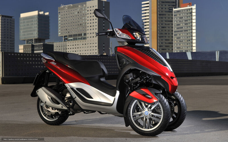 Red three-wheeled scooter in city