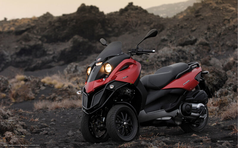 Red three-wheeled scooter in volcanic landscape