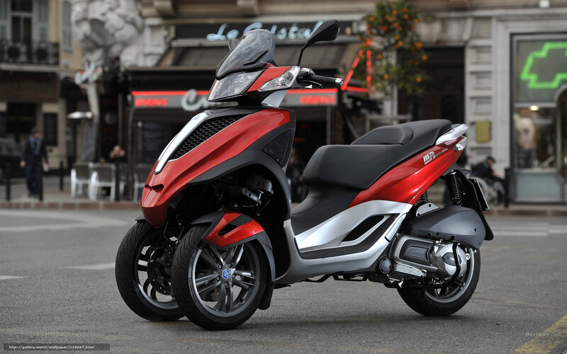 Red three-wheeled scooter on street