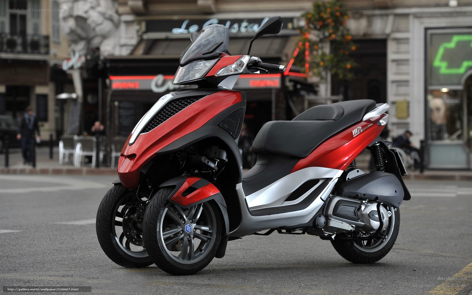 Red three-wheeled scooter on street