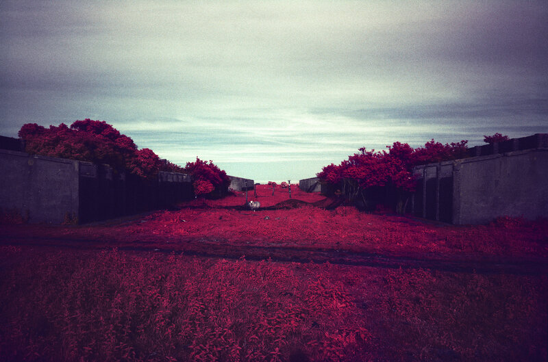 Red-tinted landscape with concrete walls