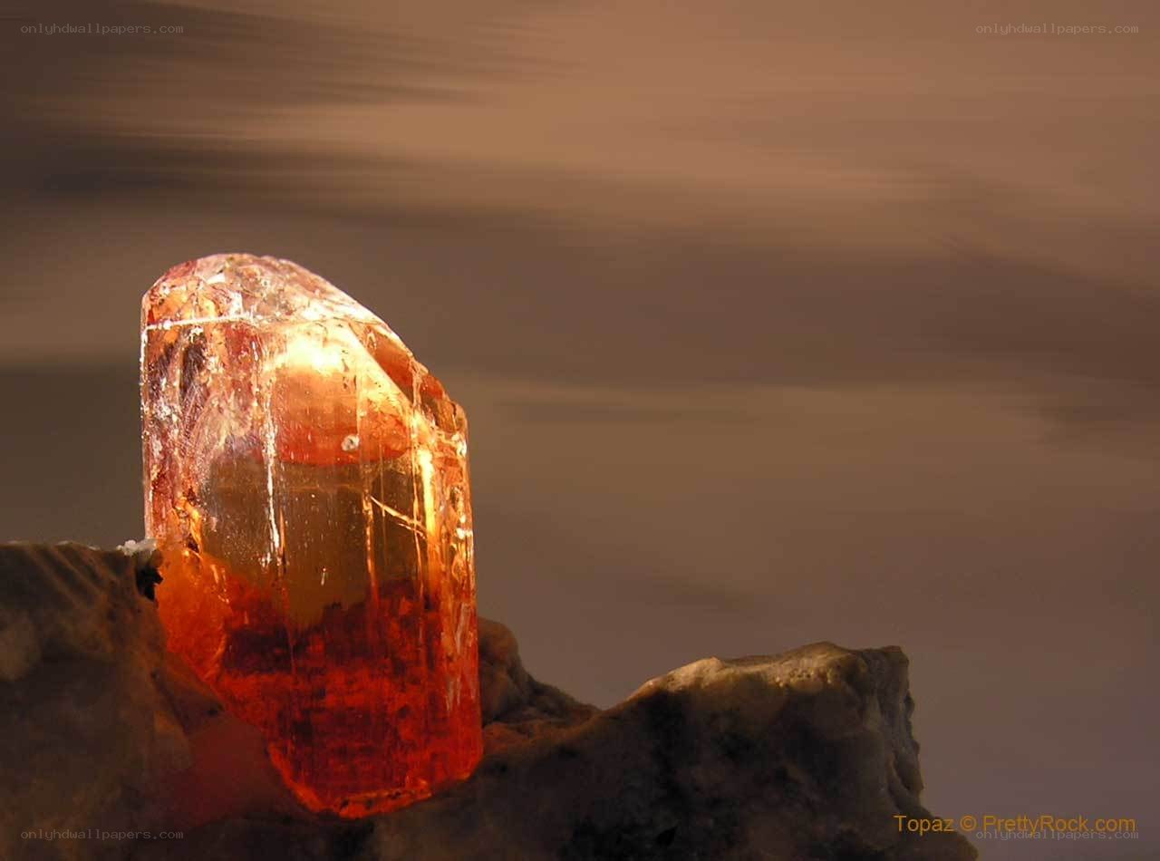 Red topaz crystal on rock