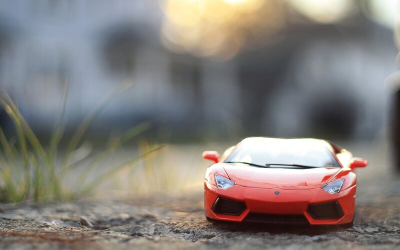 Red toy car on gravel
