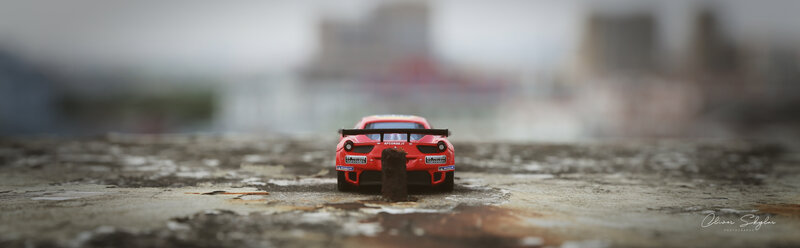 Red Toy Car on Pavement — Dramatic