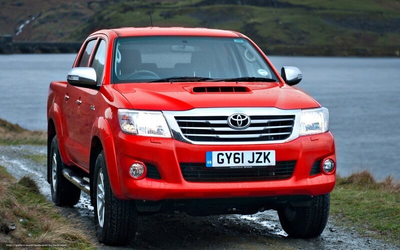 Red Toyota Hilux by a lake