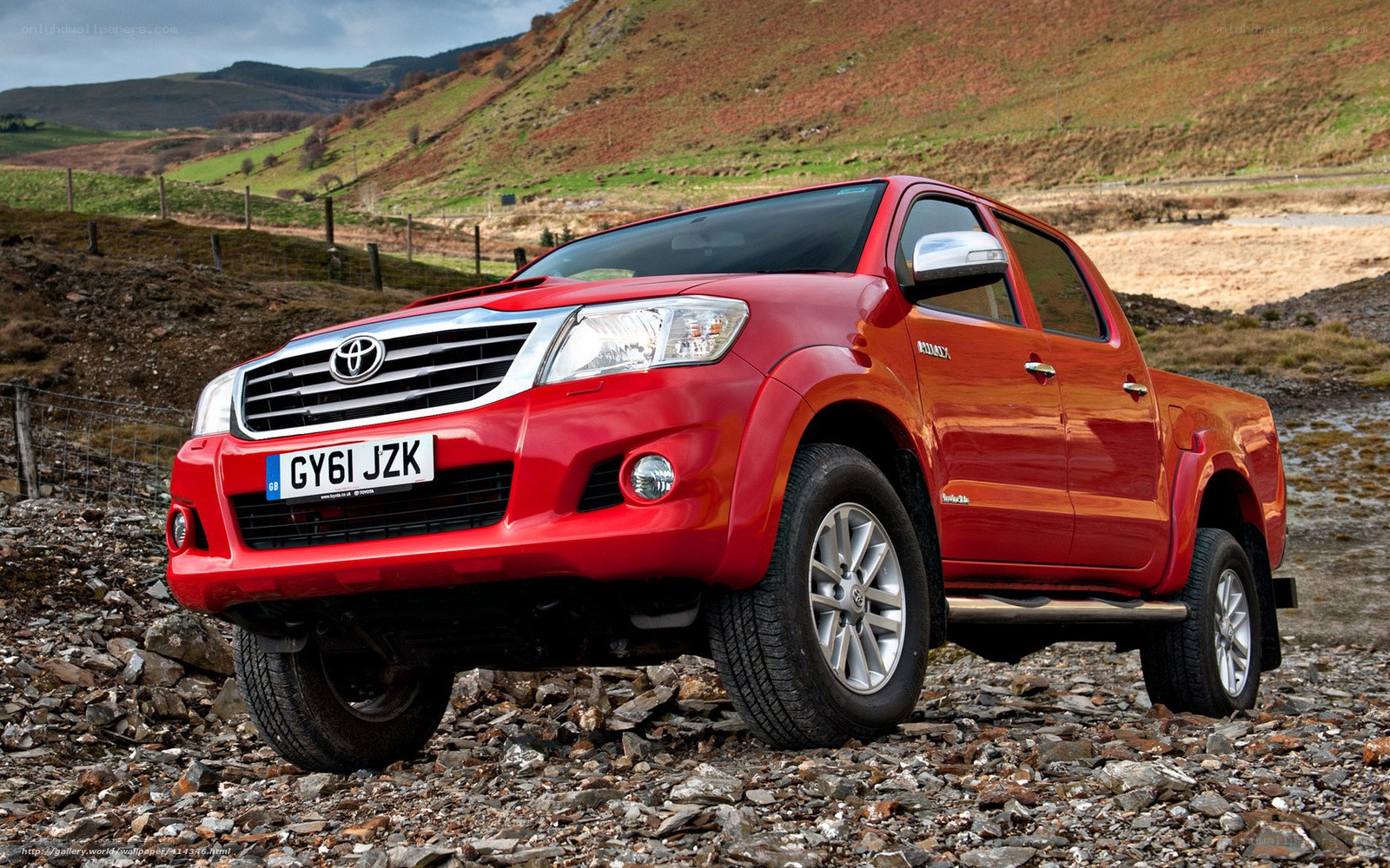 Red Toyota Hilux on rocky terrain
