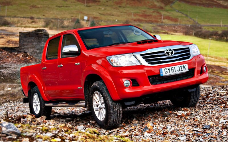 Red Toyota Hilux on rocky terrain