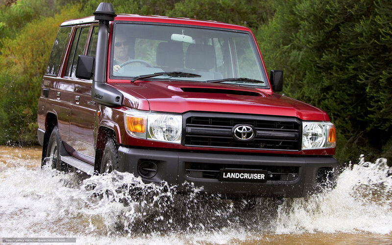 Red Toyota Land Cruiser crossing water