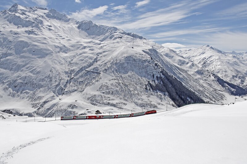 Red train in snowy mountains
