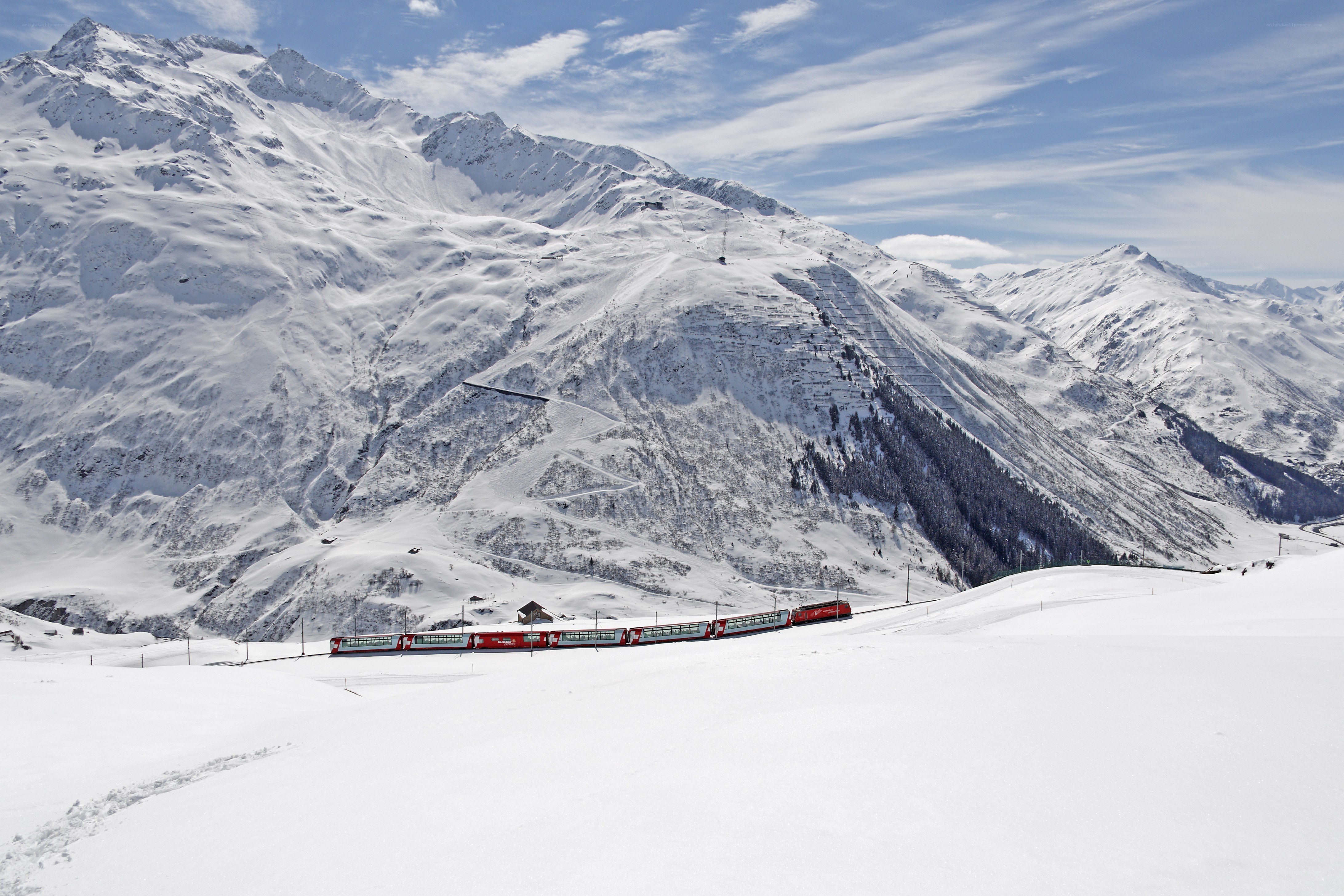 Red train in snowy mountains