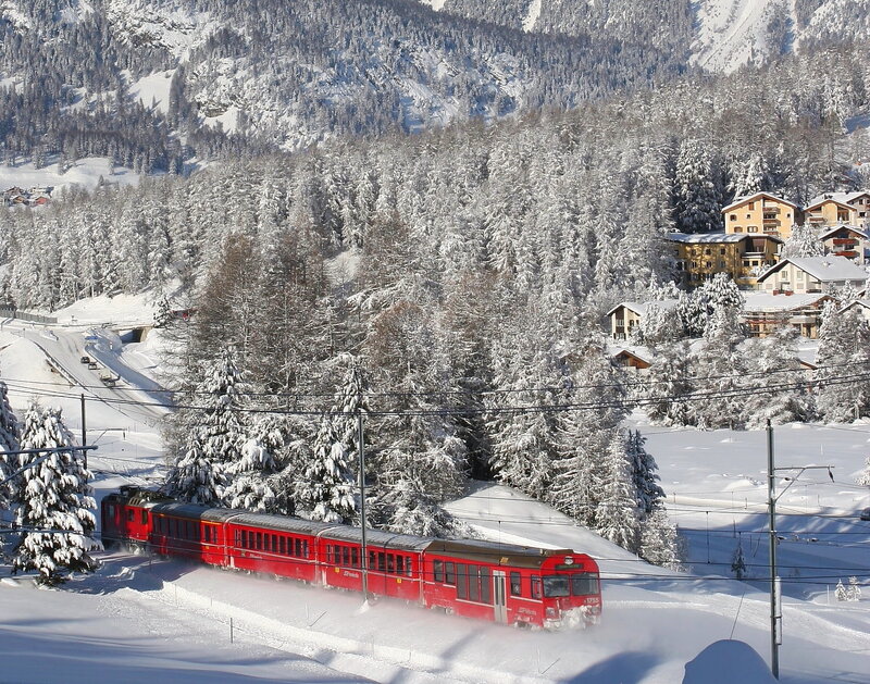 Red train in snowy mountains