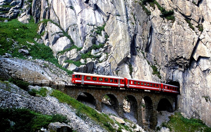 Red train on mountain bridge