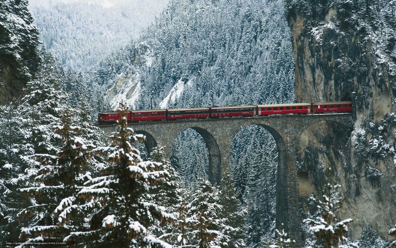 Red train on snowy bridge