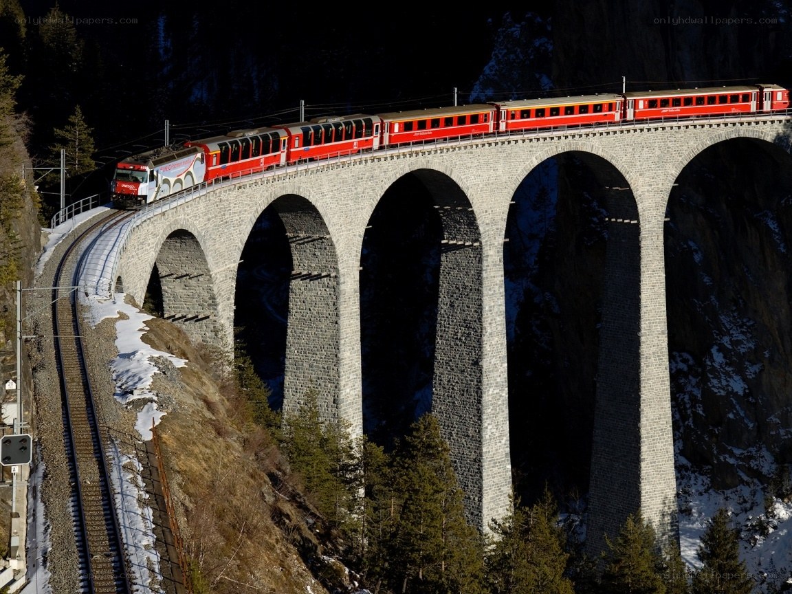 Red train on stone viaduct