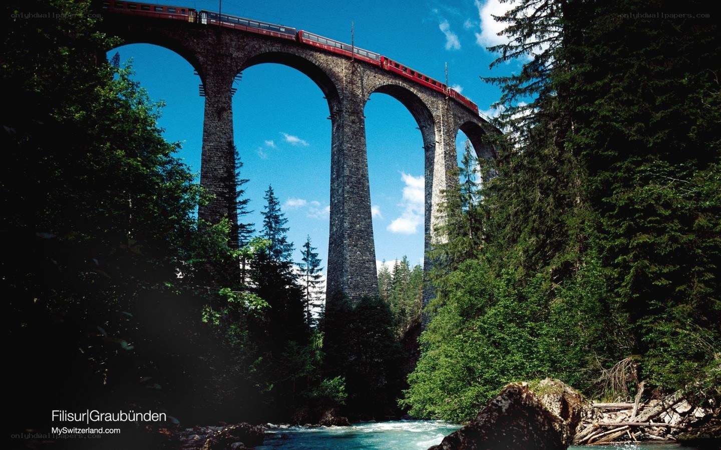 Red train on stone viaduct