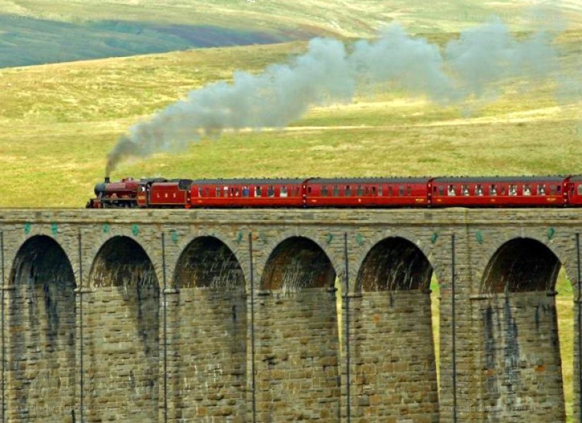 Red train on stone viaduct