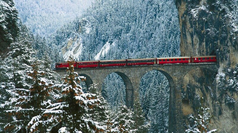 Red Train on Viaduct — Serene, Winter, Photograph, Snow-covered Trees, Stone Bridge