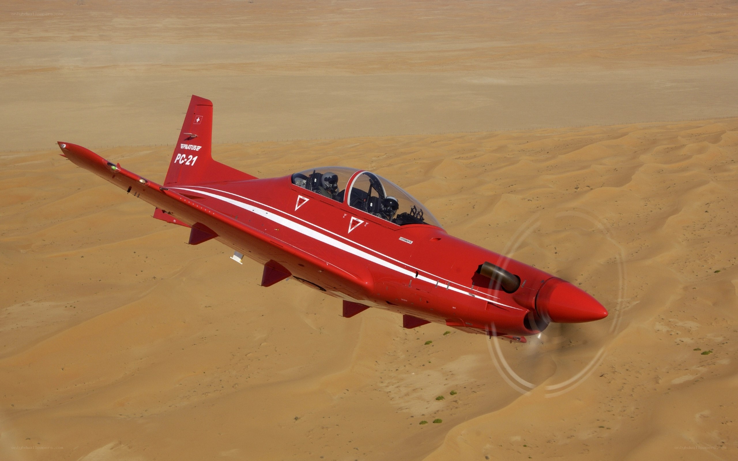 Red training jet over desert