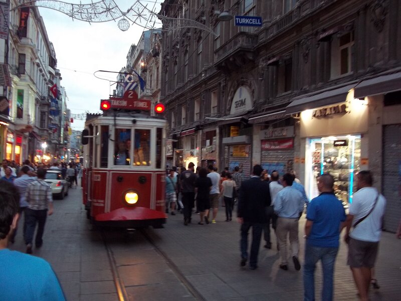 Red tram on a busy street