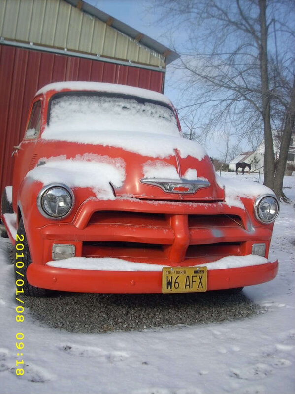Red truck covered in snow