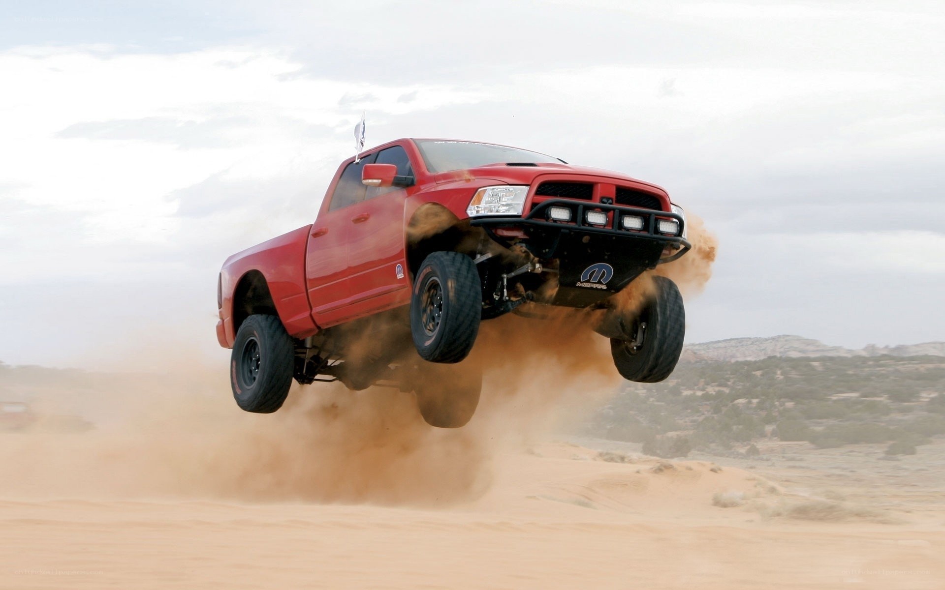 Red truck jumping in desert