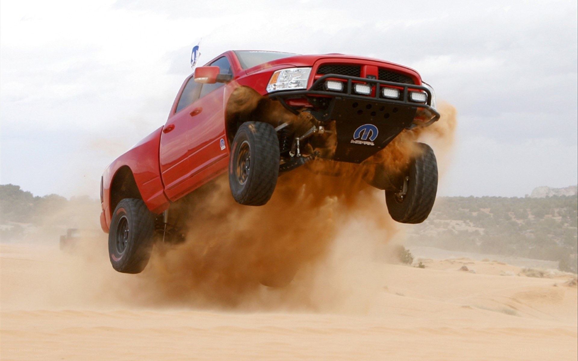 Red truck jumping in desert
