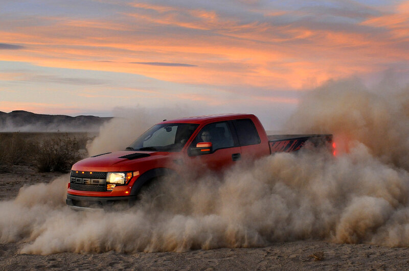 Red truck kicking up dust