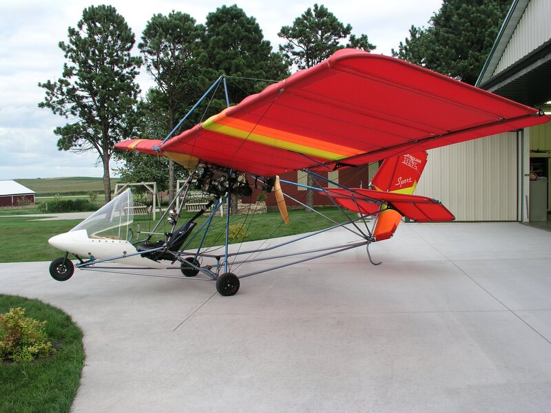 Red ultralight aircraft on tarmac