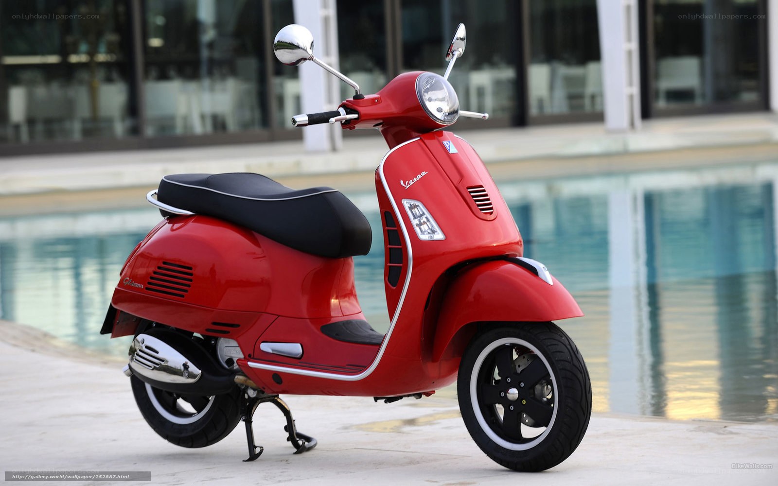 Red Vespa scooter by pool