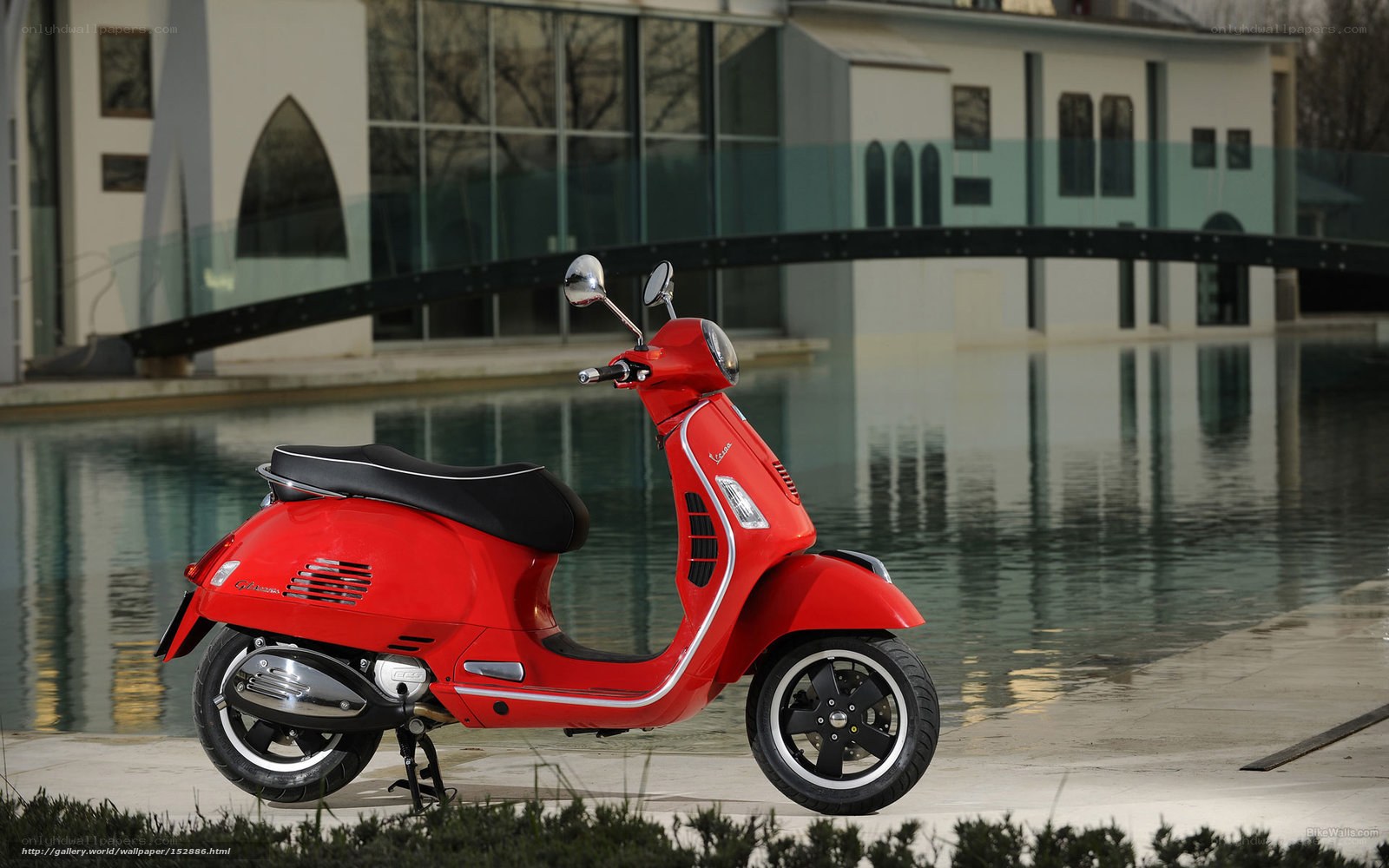 Red Vespa scooter by water