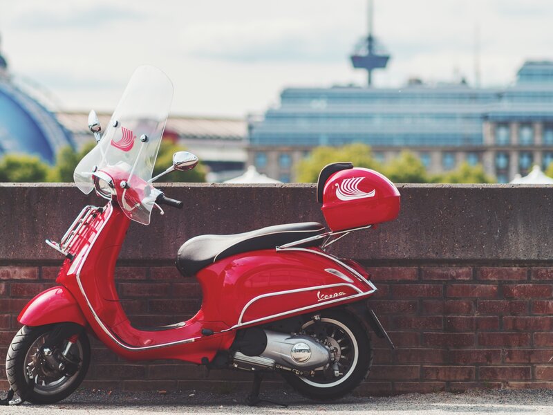 Red Vespa scooter on city street