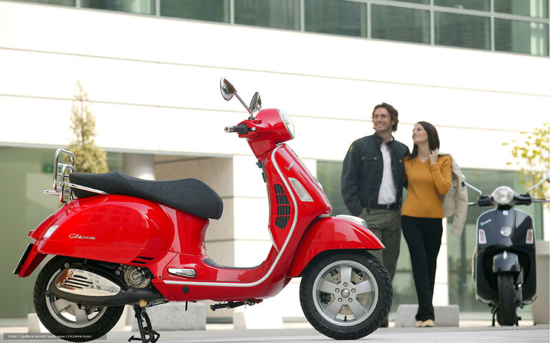 Red Vespa scooter with couple