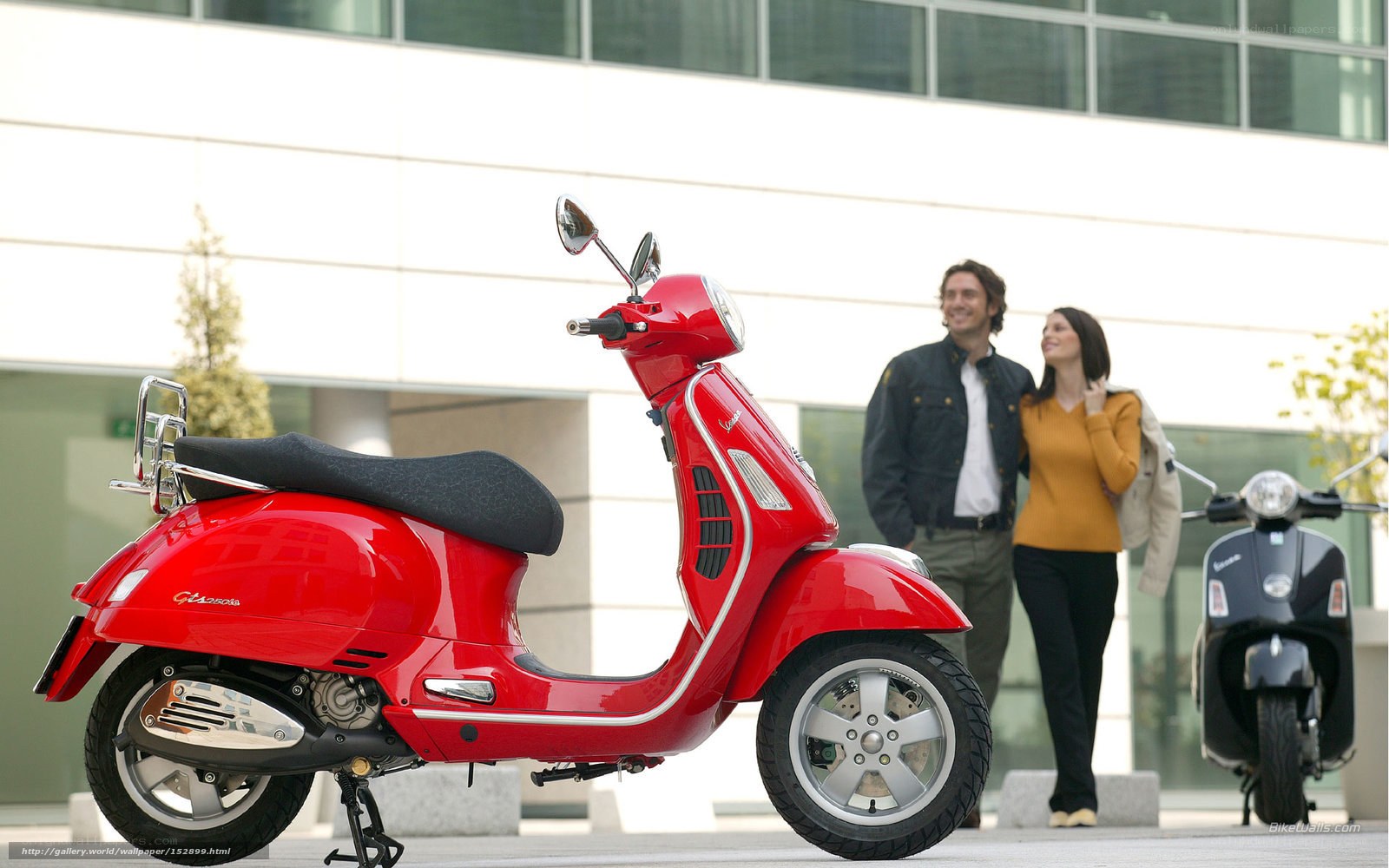Red Vespa scooter with couple